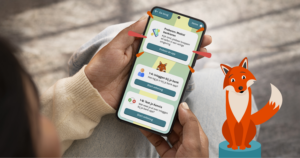 Een persoon heeft een mobiel in zijn hand met daarop het startscherm van DigiHandig. Rechts onder op de foto staat een tekening van een vos, het beeldmerk van DigiHandig.