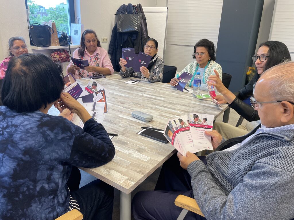 Afbeelding van workshopdeelnemers die samen flyers bekijken tijdens Workshop 3 (Veilig Bankieren)